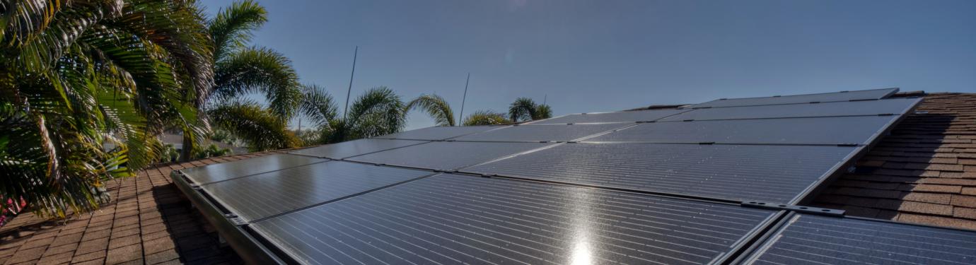 house in Florida with rooftop solar panels and the sun in the sky